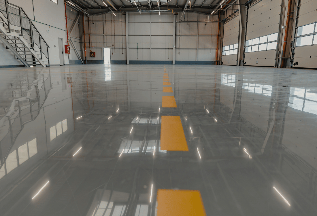 Industrial epoxy resin floor with demarcation lines for a car servicing garage.