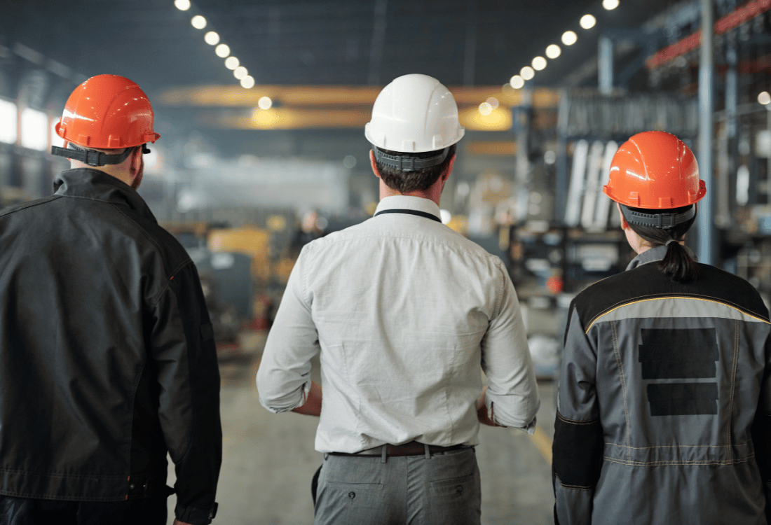 A contractor assesses the condition of a warehouse floor with industrial facility managers to recommend the best resin flooring solution.