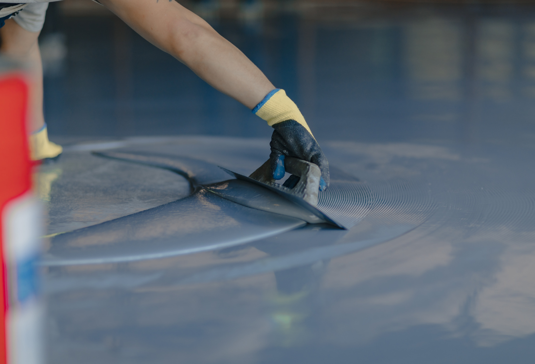 Hygienic resin flooring being installed in a warehouse.