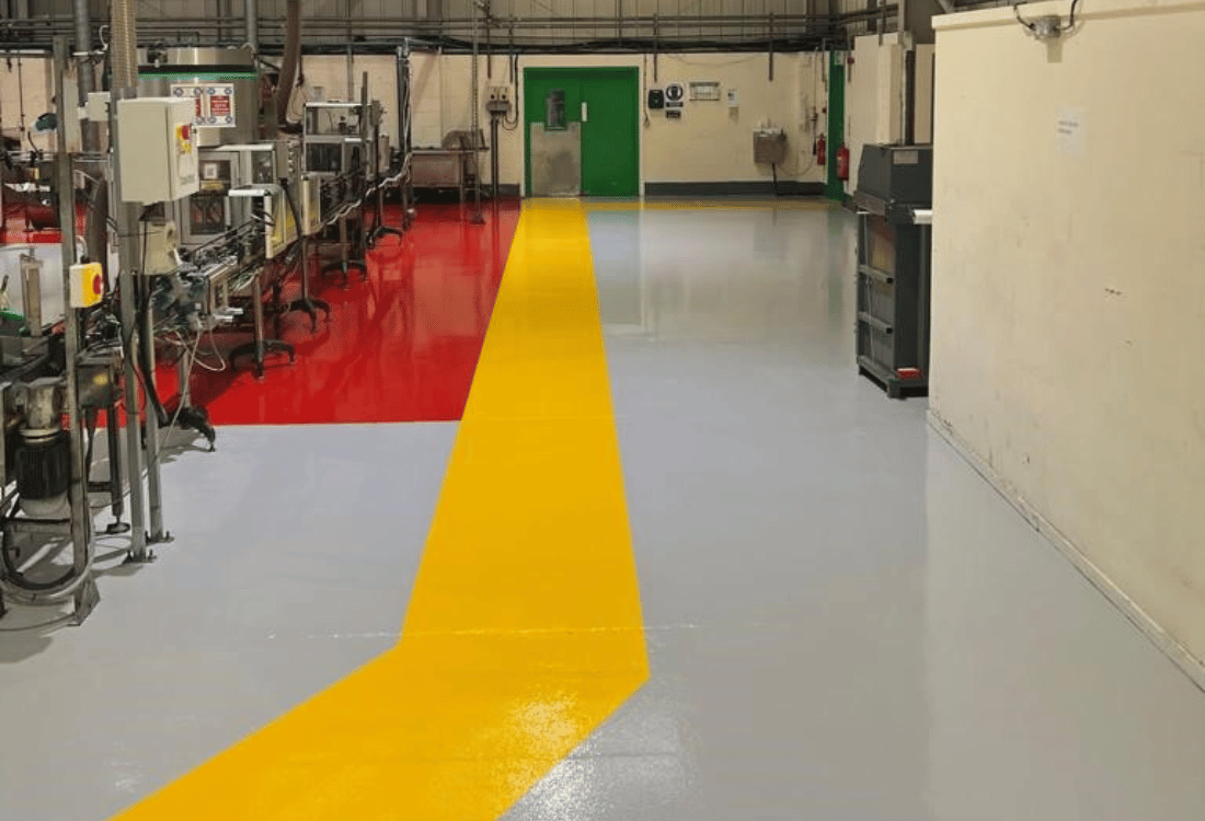 Resin floor demarcation to direct foot traffic at an aerosol filling manufacturer.
