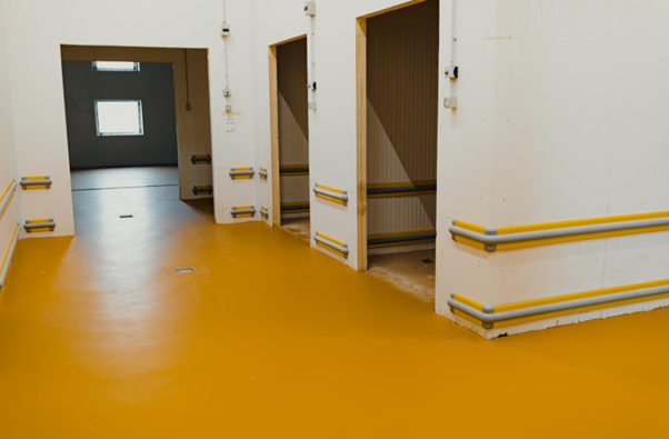 Industrial flooring specialist carrying out resin floor repair work in a commercial facility to restore damaged surfaces.